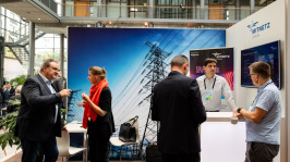 Menschen unterhalten sich an einem Ausstellungsstand
