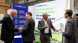 Menschen unterhalten sich an einem Ausstellungsstand