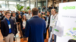 Menschen unterhalten sich an einem Ausstellungsstand