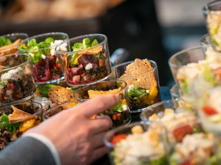 eine Hand greift nach einem Glas mit Essen