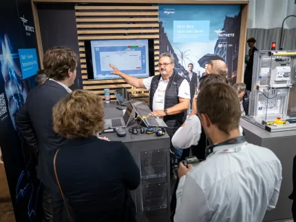 Ein Mann demonstriert etwas an einem Ausstellungsstand auf dem Treffpunkt Netze 2025