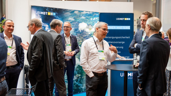 Menschen unterhalten sich an einem Ausstellungsstand