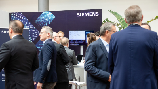 Menschen unterhalten sich vor einem Ausstellungsstand