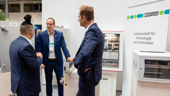 Menschen unterhalten sich an einem Ausstellungsstand