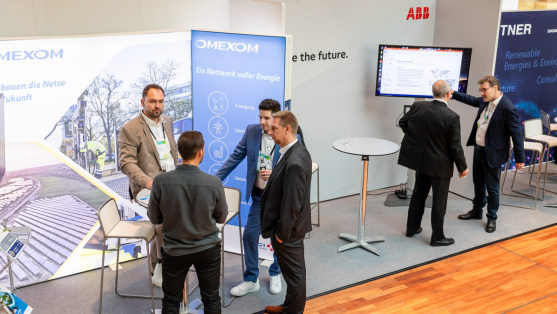 Menschen unterhalten sich an einem Ausstellungsstand